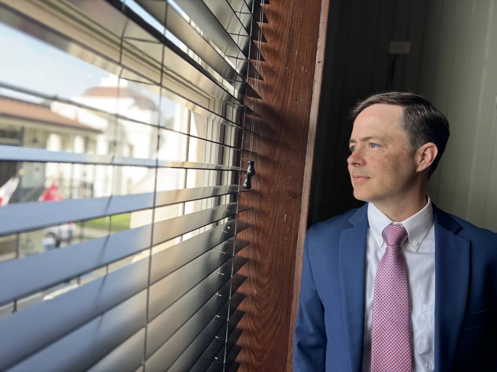 Paul Arceneaux looking out an office window onto downtown Thibodaux